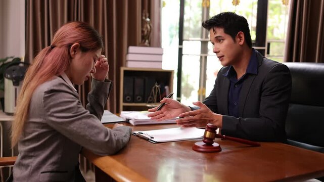 A lawyer providing legal counsel to a client, with detailed documents laid out on the desk and a judge's gavel nearby, symbolizing professionalism, legal consultation, and the judicial process.