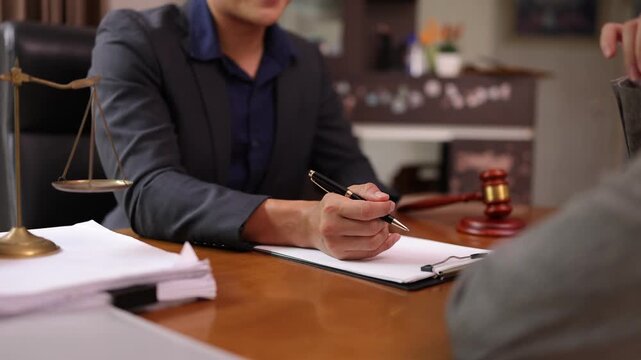 A lawyer providing legal counsel to a client, with detailed documents laid out on the desk and a judge's gavel nearby, symbolizing professionalism, legal consultation, and the judicial process.