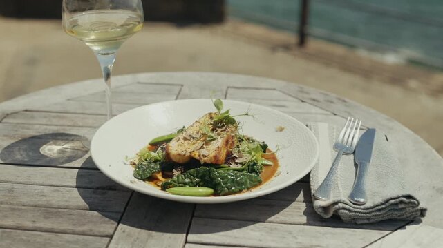 Seafood dish with white wine on a wooden table near the ocean