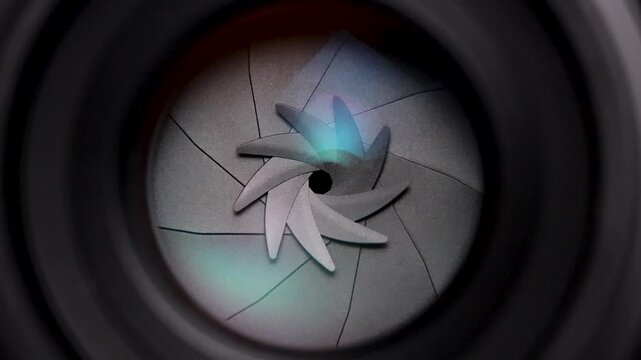 Close-up macro shot of a camera lens aperture smoothly opening from a narrow to a wide setting, revealing the precision of optical mechanics