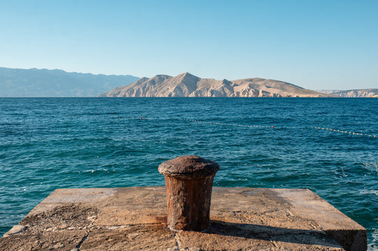 Rusty bollard on a stone pier overlooking the Adriatic Sea in Croatia