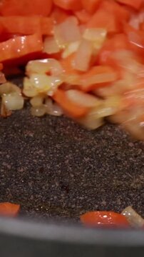 Diced Onions and Carrots Saut&eacute;ing in Hot Oil in Pot Close Up