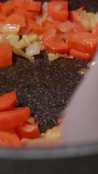 Diced Onions and Carrots Saut&eacute;ing in Hot Oil in Pot Close Up