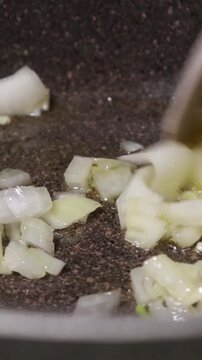 Diced Onions and Carrots Saut&eacute;ing in Hot Oil in Pot Close Up