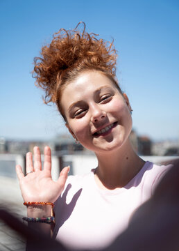 Point of view of a young redhead woman smiling and taking a selfie, first-person view