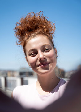 Point of view of a young redhead woman smiling and taking a selfie, first-person view