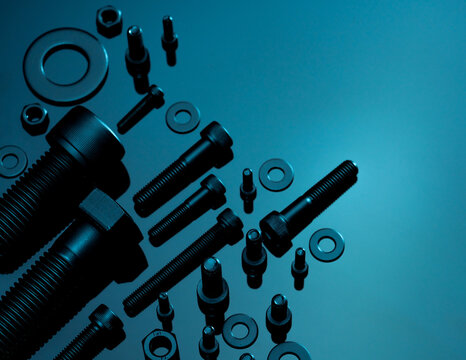 Metal Bolts, nuts, and washers. Fasteners equipment. Hardware tools. Stud bolt, flat washers, hex nuts, and hex head bolts in workshop. Threaded fastener use in automotive engineering. Hexagonal bolt.