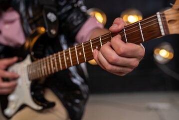 Fototapeta premium Close up of fingers on electric guitar fretboard