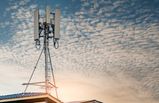 Telecommunication tower with blue sky and white clouds background. Antenna on blue sky. Radio and satellite pole. Communication technology. Telecommunication industry. Mobile or telecom 4g network.