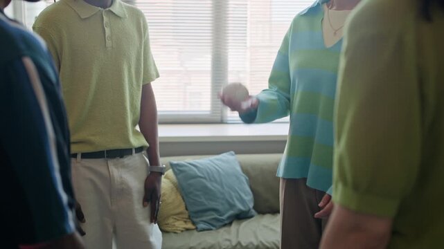 Cropped shot of diverse young adult colleagues standing in circle and tossing baseball to each other during team building session. Footage suitable for corporate training and human resources videos