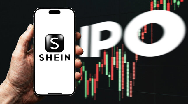 SHEIN Logo Displayed on Smartphone Screen Held in Hand Against IPO Text and Stock Market Candlestick Chart Background