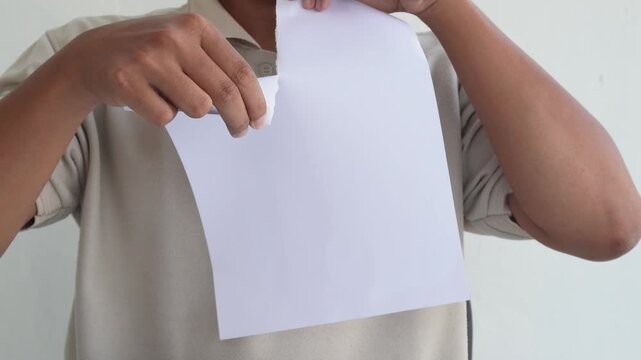 Close-up view of a man tearing paper with his hands