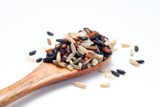 Seven different organic rice grains in a wooden spoon on white backgroiund, Healthy food concept