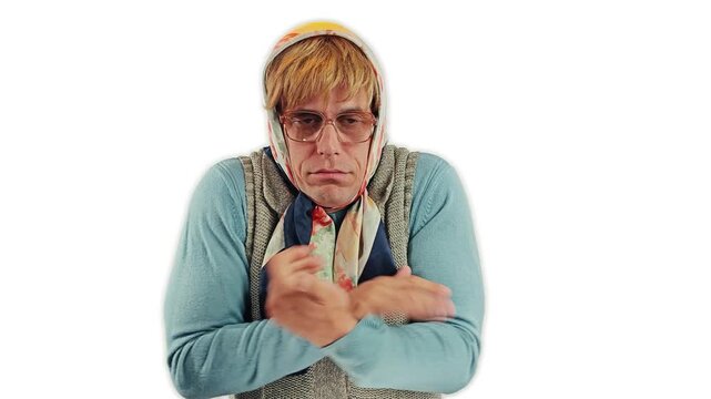 A funny cross dressing actor as an old grandmother freezing and warming up hands