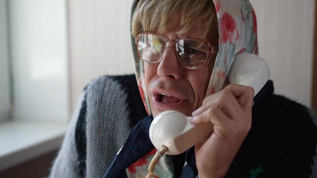 Funny grandmother talking on a vintage rare rotary telephone with happy smile