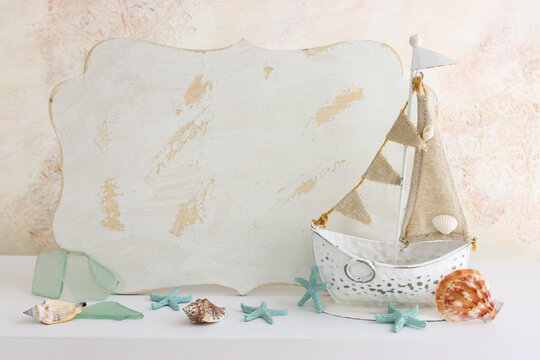 summer background with boat, blue sea glass and shells