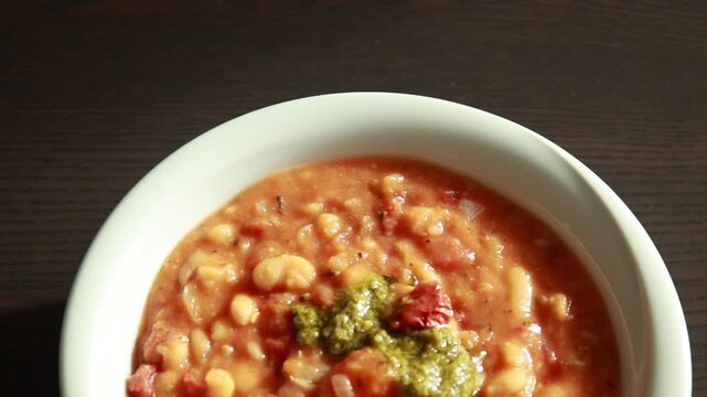 Serving Delicious Bean Stew with Sun Dried Tomatoes in Bowl Close Up