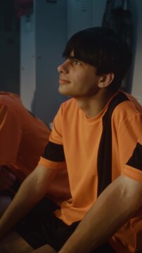 In Locker Room, Diverse Group of Teenage Boys Sits Absorbed in Theoretical Session With Mentor. Sport Education, Disciplined Listening, Development Character Through Athletic Training. Vertical Shot.