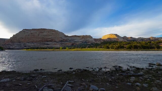 Harding Hole backcountry camping overlook spot, expansive river and canyon landscape with layered hills and sweeping cloud patterns, establishing pan right