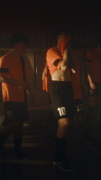 Coach Uses Motivational Speech Restore Team Morale and Mental Toughness. Boys in Orange Uniforms Look Heartbroken and Slumped With Disappointment. Failure, Adaptive Sports Psychology. Vertical Shot.