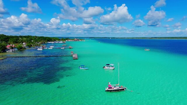 Aerial view of sailboats moored on the turquoise Bacalar Lagoon, Quintana Roo, Mexico, wooden piers reaching into the calm freshwater.