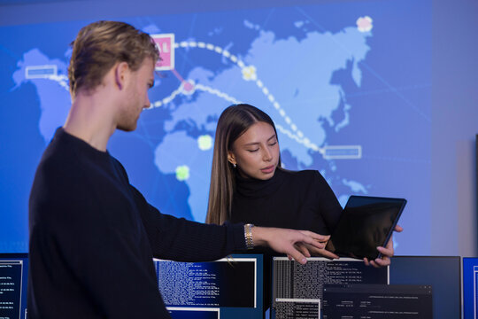Team collaborating in a cybersecurity operations center with data visualization screens