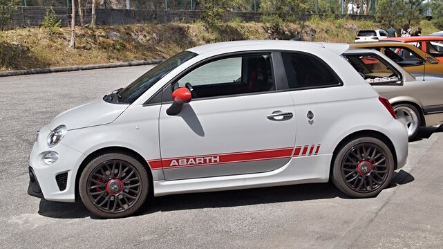 White Abarth 595 parked at an outdoor car show