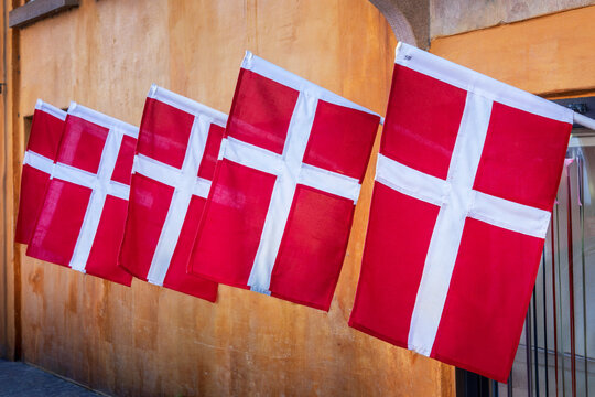 Photo of many Danish flags in a colorful street of Copenhagen, Denmark