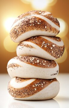 Stack of fresh breakfast bagels with seeds isolated on a warm golden background
