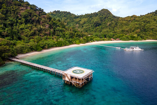 Aerial view of tropical beach landscape with floating jetty and helipad in front of the resort at Nyaung Oo Phee island in Myanmar. Travel attraction for summer vacation in Andaman sea, Burma.