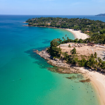 Aerial top view of Surin beach and Pansea Beach in Phuket, Thailand. Turquoise waves reach the Andaman sea coastline on a sunny day. Travel attractions for summer vacation in southeast asia.