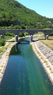 Aerial view of the arched stone structure of the historic Tsarev Bridge crossing the Zeta River