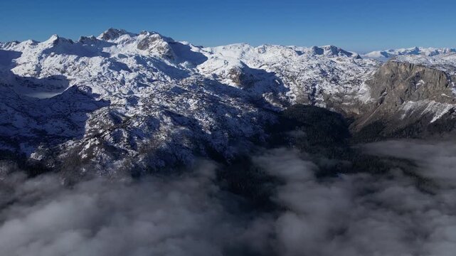 Drone View of Durmitor National Park in Montenegro During Winter with Snow Covered Peaks and Foggy Valley