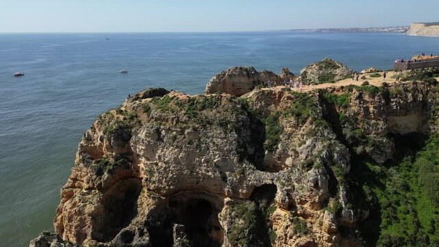Drone Aerial View of Ponta da Piedade Coastline in Lagos, Algarve, Portugal with Boat Tours on a Summer Day