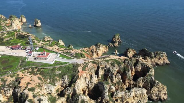 Drone Aerial View of Ponta da Piedade Coastline in Lagos, Algarve, Portugal with Boat Tours on a Summer Day