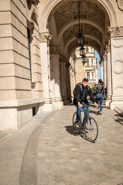 Mature man riding bicycle in historic city street