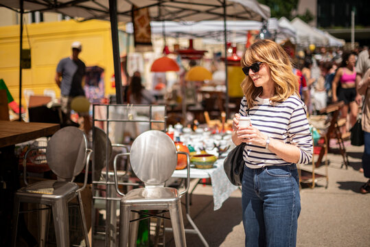 Blond haired mature woman walking at the flea market in an european city
