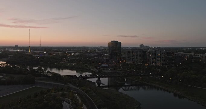 Columbus Ohio Aerial v29 low flyover along Scioto river capturing views of Arena District and North Franklinton neighborhoods along the bend at sunset dusk  - Shot with Inspire 3 8k - Sept 21st 2023