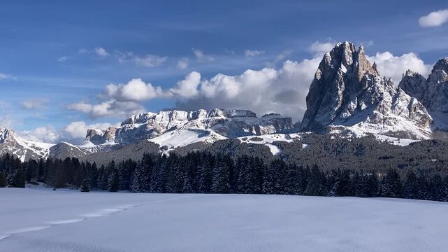 Scenic winter view of the cross-country skiing trail near Compatsch (Compaccio) on Alpe di Siusi (Seiser Alm) in the Dolomites, South Tyrol, Italy. Fresh snow, traditional alpine huts. 