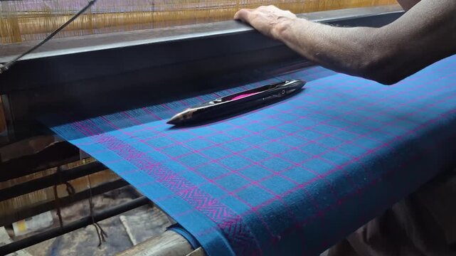 4k video of a handloom weaver in India working in his loom.