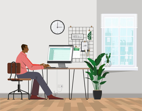 A freelancer man works behind a laptop. Home office workplace.
