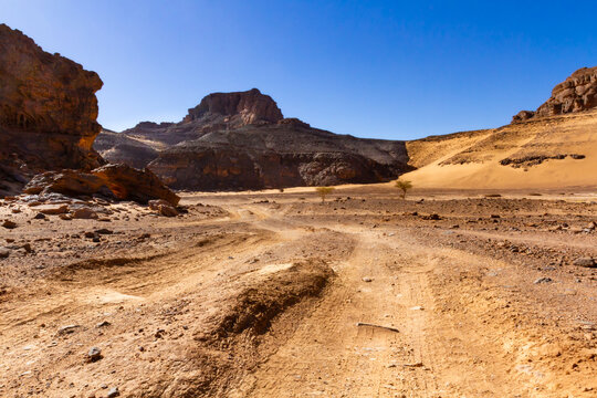 A desert landscape.Dirt road among the rocks.Tadrart Rouge mountains. Tassili n'Ajjer National Park Algeria, Africa