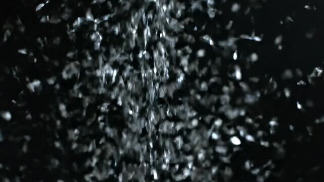Sparkling silver particles falling on abstract black background