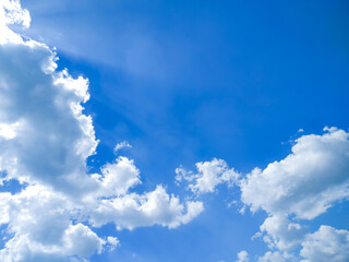 Obraz premium Beautiful clear blue sky with scattered soft white cumulus clouds. Ideal as an aesthetic background for graphic design, web headers, or nature-themed projects with space for custom text