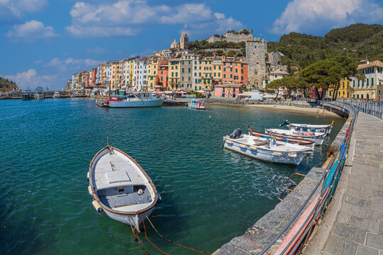 View from the sea of ​​the coast of the town of Portovenere, province of La Spezia, Italy, with a multitude of picturesque multicolored houses and the tourist port. In the background is Doria Castle.