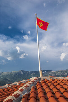 The flag of the Republic of Montenegro flying on the roof of the Budva fortress ramparts.