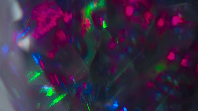 Diamond Facets Glint in the Dark. The light passes through the facets of a slowly rotating diamond and creates repetitive sparkling highlights and rainbow colors