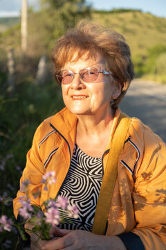 Elderly woman portrait with a bouquet of field flowers outdoor