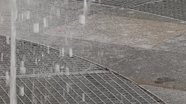 Water Fountain Jets Splashing on Urban Stone Tiles and Metal Grates