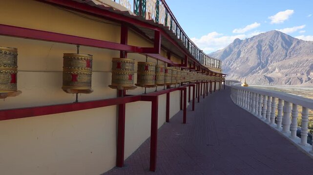 Buddhist prayer wheels spinning in Leh Ladakh, India. Prayer wheels in Diskit Buddhist temple in Himalaya spinning with decorated letters of mantra